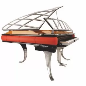 A piano with a glass top and metal legs.