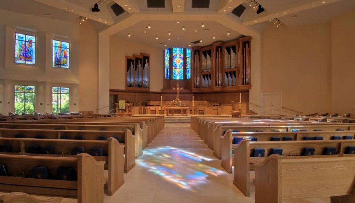 A church with stained glass windows and pews