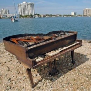 damaged baby grand piano on the beach in Miami