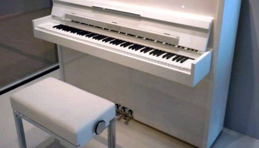 A white piano sitting in front of a wall.