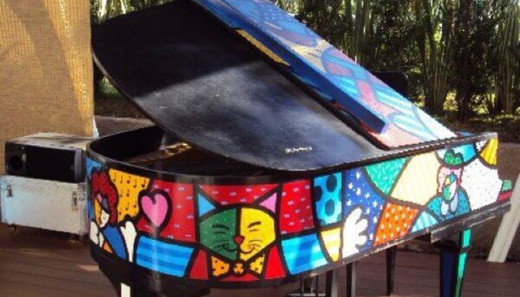 A colorful piano sitting on top of a wooden floor.