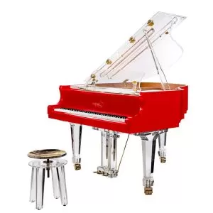 A red piano with clear legs and a stool